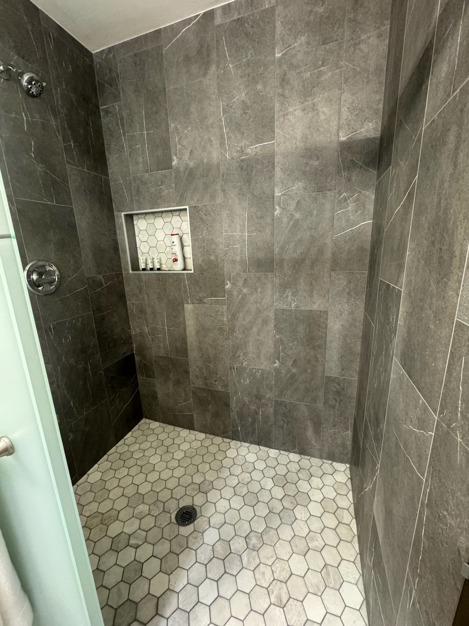 Spa-style walk-in shower with rain head, large-format tile walls, and glass enclosure in Charlotte NC